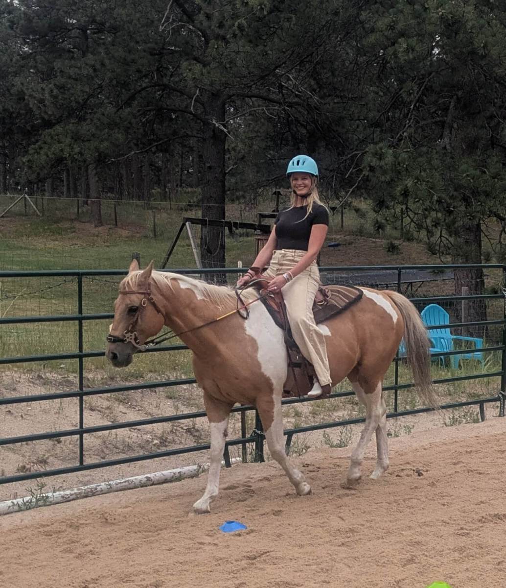 Rider on palomino horse in arena