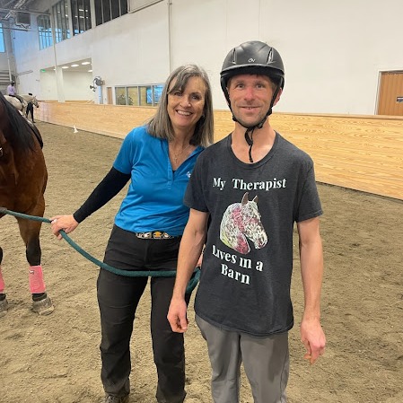 Two people in arena with horse