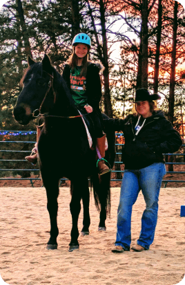 Beginner lesson with instructor on black horse